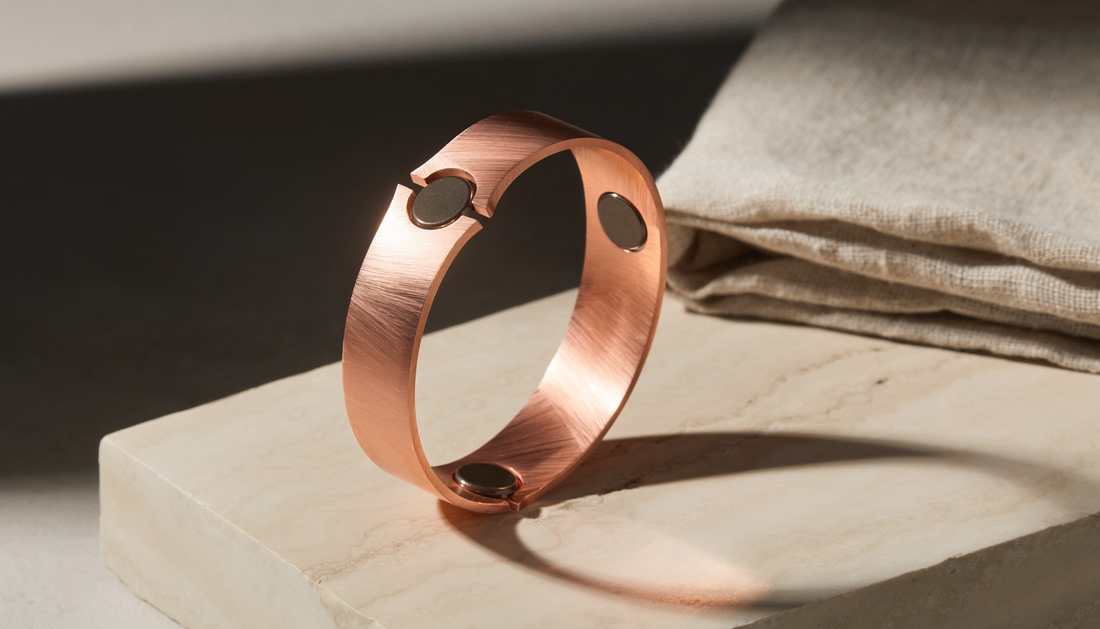 Refined copper-toned magnetic cuff bracelet on warm ivory stone and linen