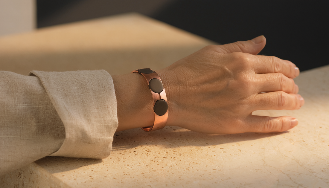 Copper-toned magnetic bracelet worn naturally with warm ivory linen and stone
